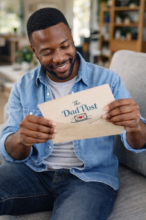 Dad sitting down and reading a heartfelt letter from The Dad Post
